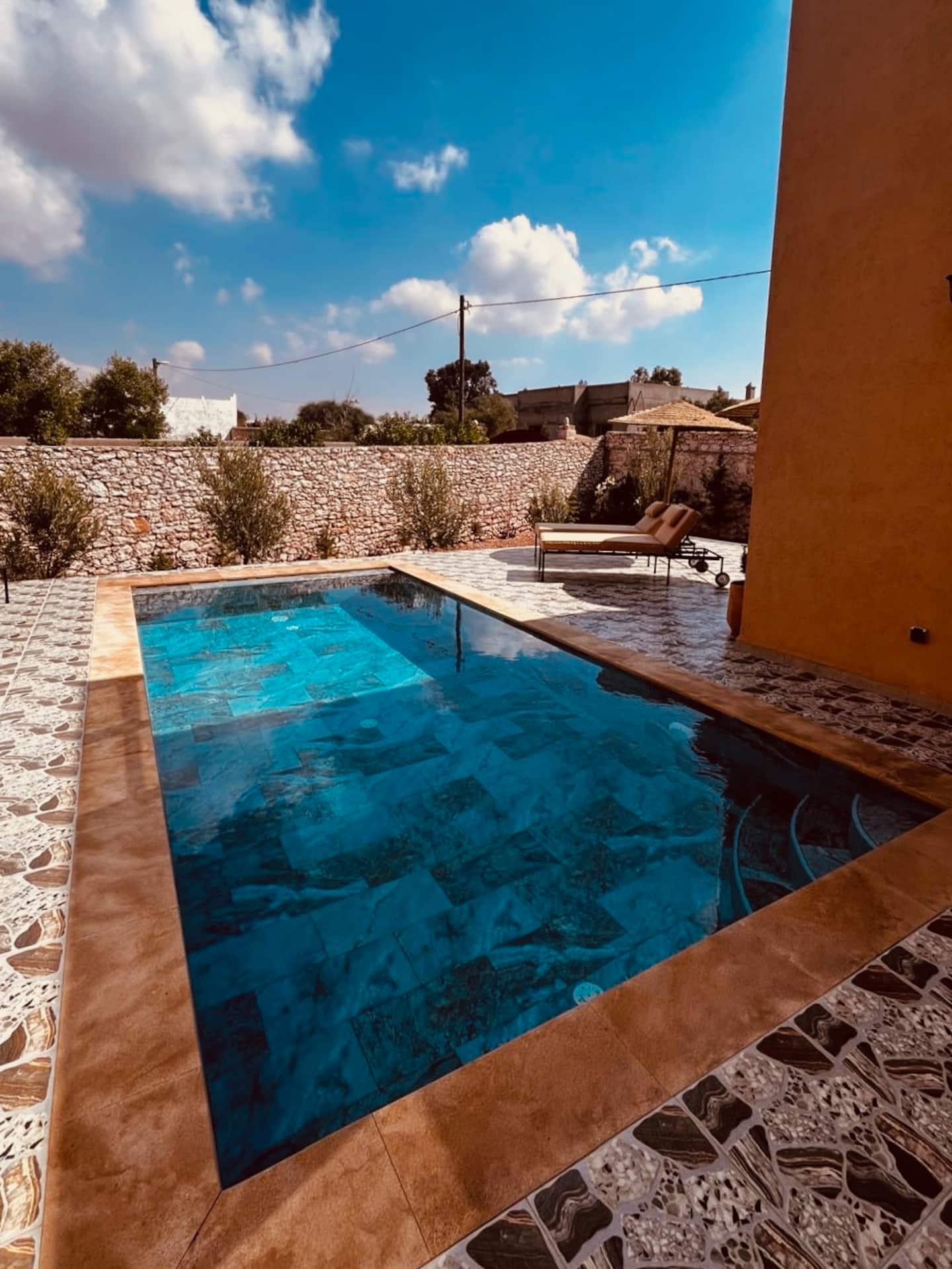 La piscine privée de la villa, entourée de son mur en pierre