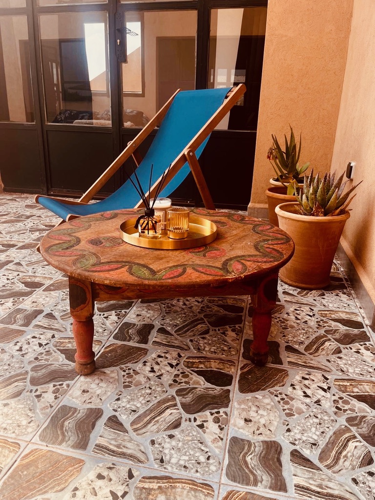Coin détente sur la terrasse, table peinte traditionnelle et transat
